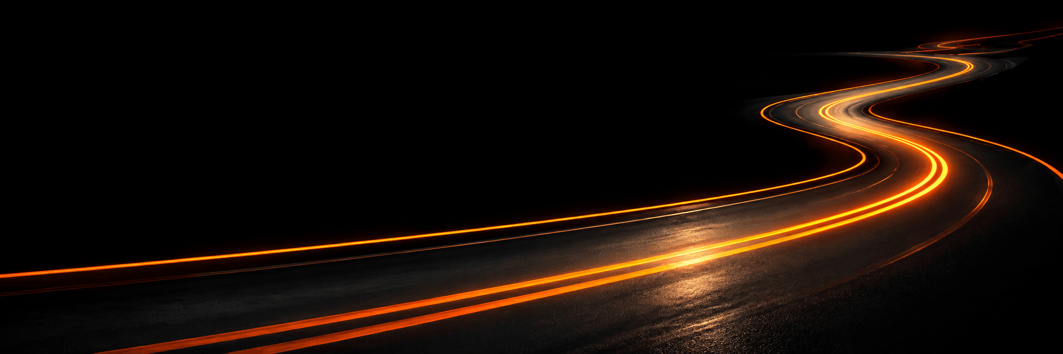Route de nuit — courbes, traces lumineuses orange